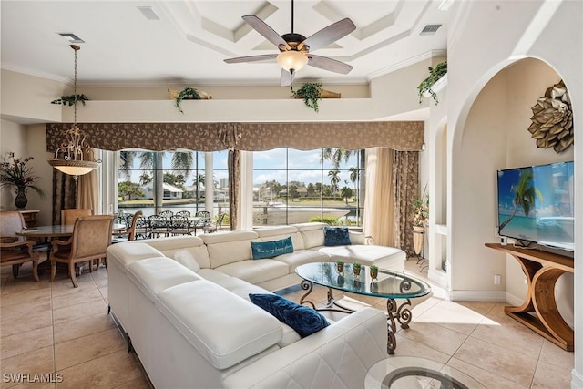 tiled living room with ceiling fan, crown molding, and a towering ceiling