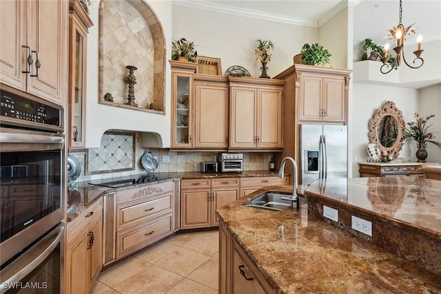 kitchen featuring sink, dark stone counters, crown molding, stainless steel appliances, and decorative backsplash