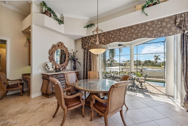 dining space featuring light tile patterned floors, ornamental molding, and a towering ceiling