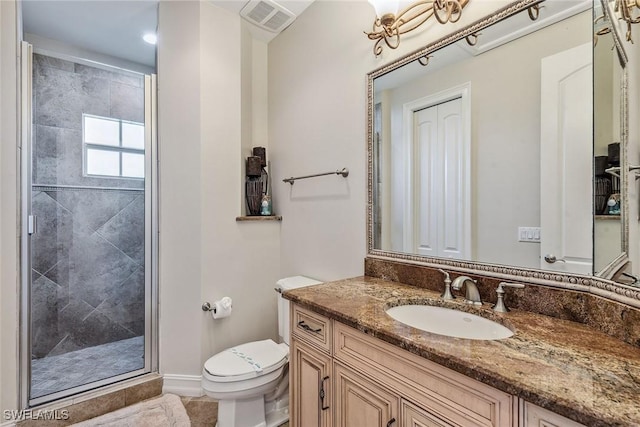 bathroom with vanity, toilet, and a shower with door