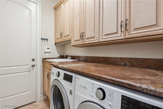 laundry area with light tile patterned floors, sink, separate washer and dryer, and cabinets