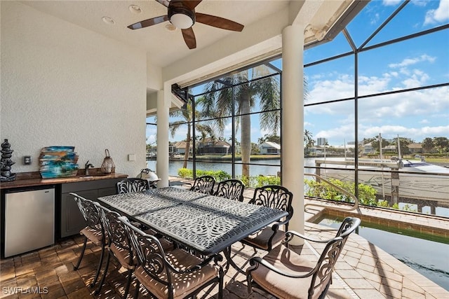 sunroom / solarium with a water view, sink, and a wealth of natural light