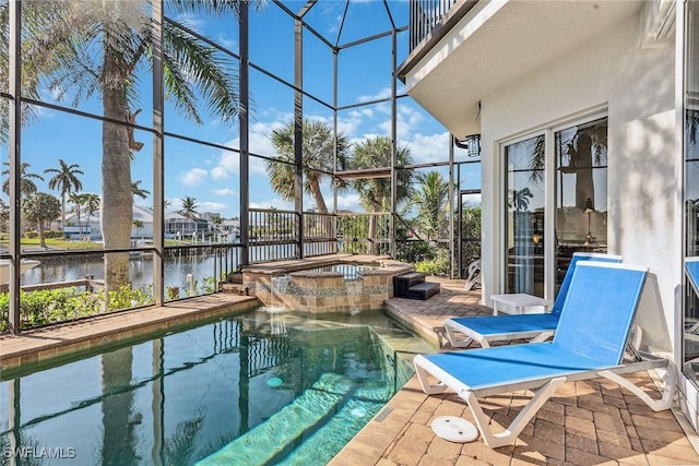 view of swimming pool with an in ground hot tub, a water view, glass enclosure, and a patio