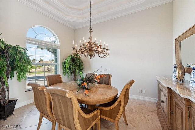 tiled dining space with a tray ceiling, an inviting chandelier, and crown molding