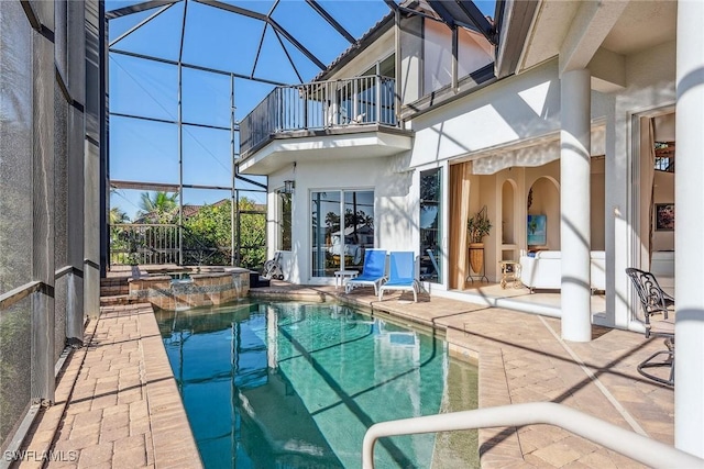 view of swimming pool with a patio area, an in ground hot tub, and glass enclosure