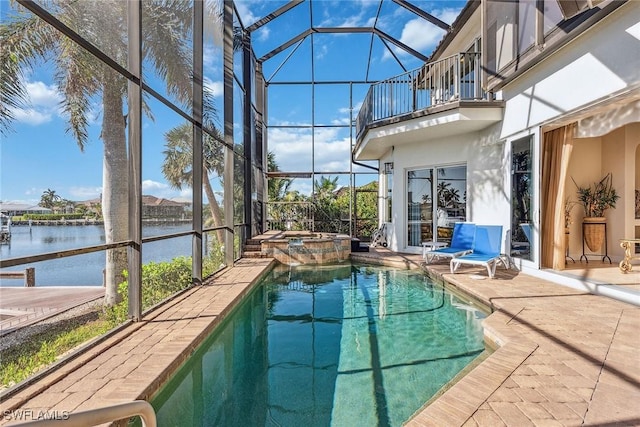 view of swimming pool with glass enclosure, a patio area, an in ground hot tub, and a water view