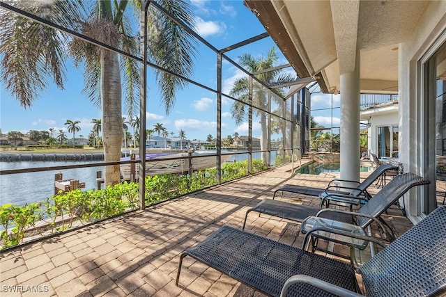 view of patio / terrace with a lanai and a water view