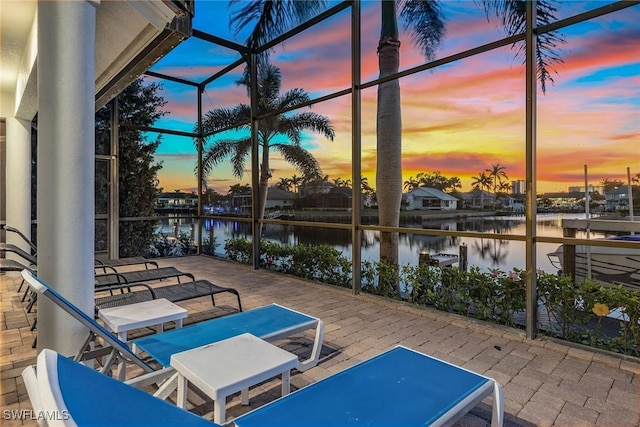 exterior space featuring a lanai, a water view, and a patio area