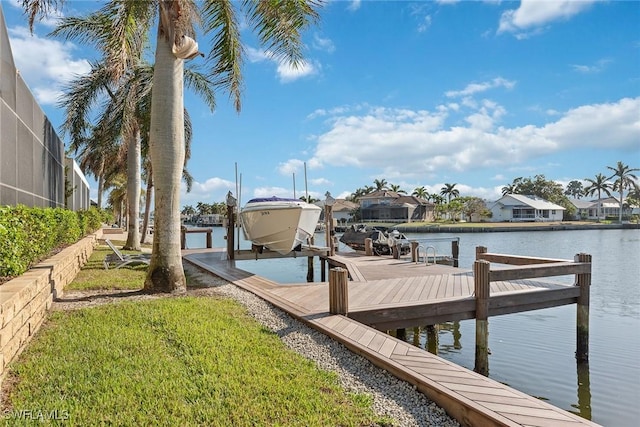 view of dock with a lawn and a water view