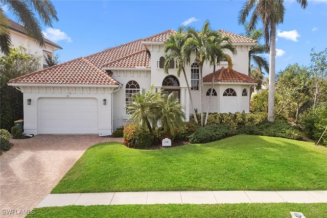 mediterranean / spanish house featuring a front lawn and a garage