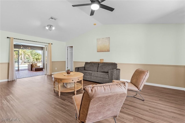 living area with lofted ceiling, a ceiling fan, visible vents, and wood finished floors