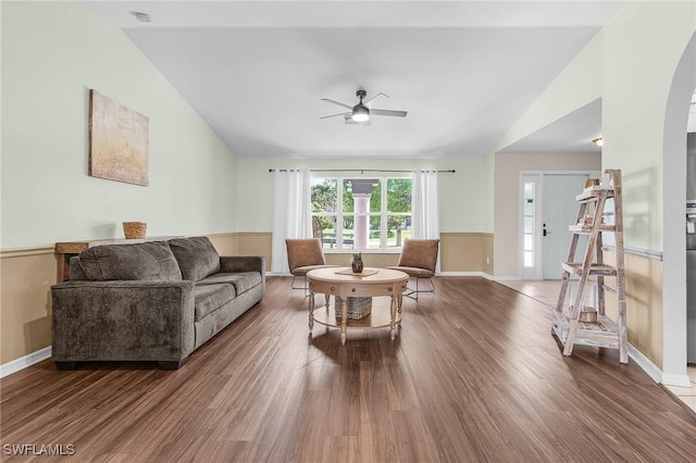 living room featuring vaulted ceiling, ceiling fan, arched walkways, and wood finished floors