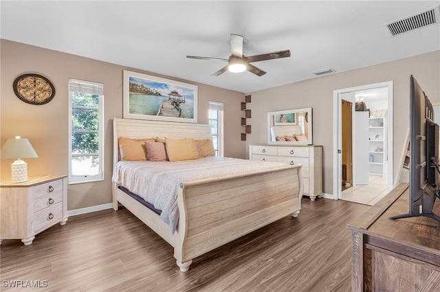 bedroom with ceiling fan, dark wood-type flooring, visible vents, and baseboards