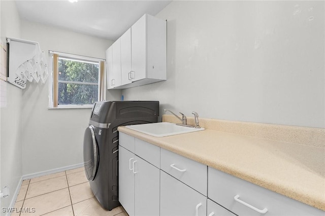 washroom with light tile patterned flooring, a sink, baseboards, cabinet space, and washer / clothes dryer