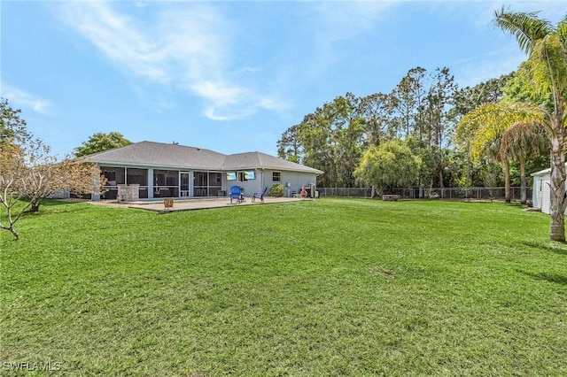 back of house featuring a lawn, a fenced backyard, and a sunroom