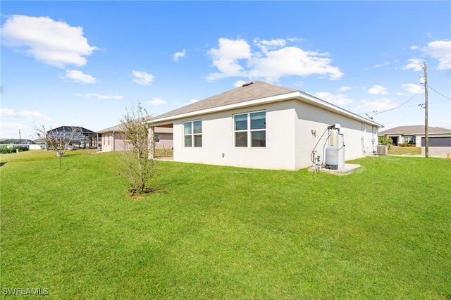 rear view of property with stucco siding and a yard