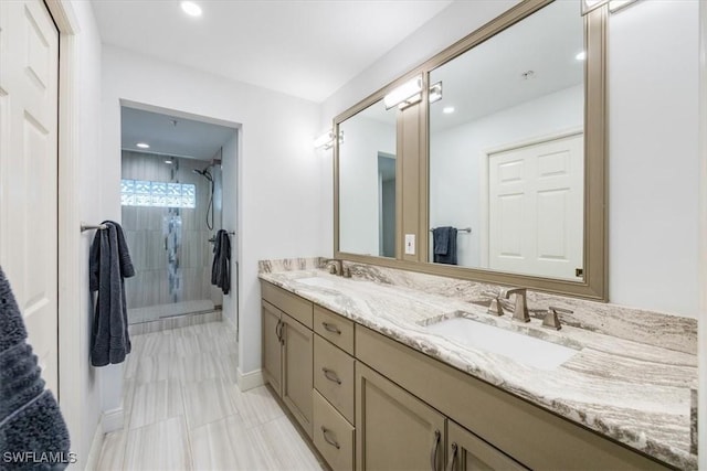 bathroom featuring double vanity, a shower stall, a sink, and recessed lighting