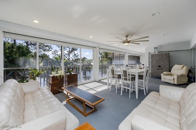 living room featuring a water view, a ceiling fan, and recessed lighting