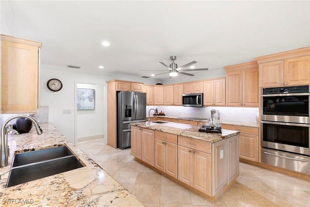 kitchen featuring a sink, a warming drawer, appliances with stainless steel finishes, and light brown cabinetry