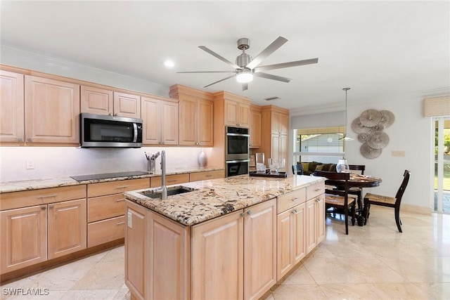 kitchen featuring an island with sink, appliances with stainless steel finishes, and light brown cabinetry