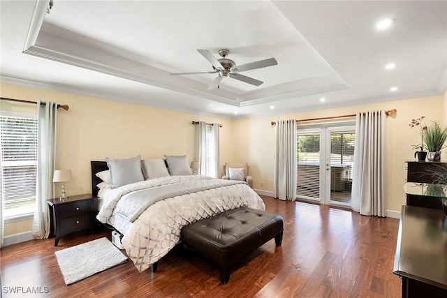 bedroom with a tray ceiling, access to outside, wood finished floors, and baseboards