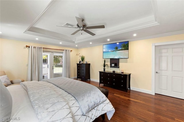 bedroom featuring crown molding, a raised ceiling, baseboards, and wood finished floors