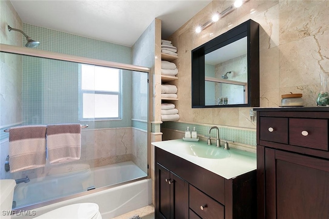 full bathroom featuring vanity, enclosed tub / shower combo, tile walls, toilet, and backsplash