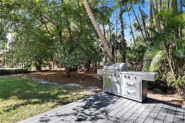 wooden terrace with a yard and a grill