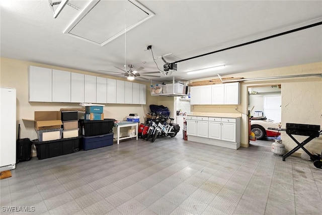 garage with a garage door opener, white refrigerator, and ceiling fan