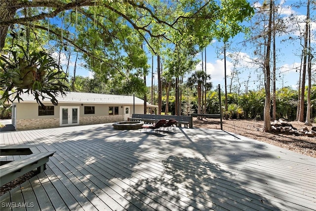 wooden terrace with french doors and a fire pit