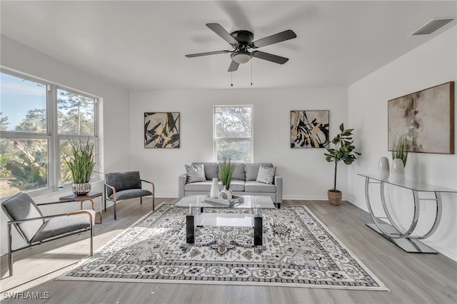 living room with ceiling fan and light wood-type flooring