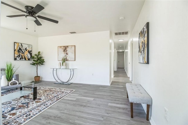 living area featuring hardwood / wood-style floors and ceiling fan