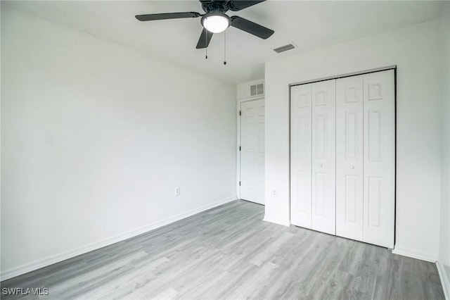 unfurnished bedroom with ceiling fan, a closet, and light hardwood / wood-style flooring