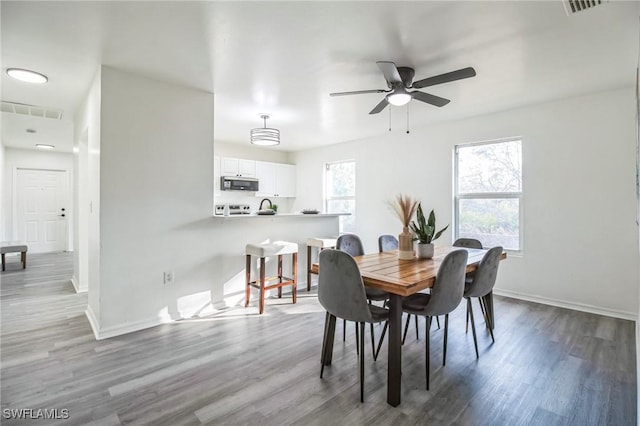 dining area with hardwood / wood-style floors and ceiling fan