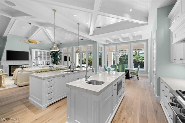 532 Pine Grove Ln, Naples, FL 34103 - kitchen featuring beam ceiling, appliances with stainless steel finishes, a center island with sink, and a sink