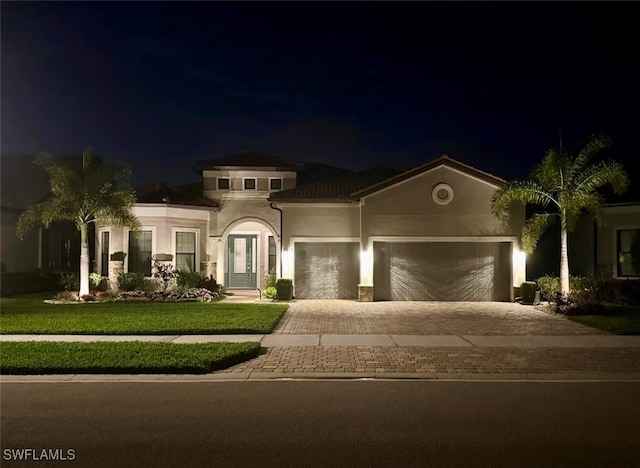 view of front of house featuring a garage and a lawn