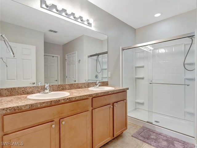 bathroom with walk in shower, vanity, and tile patterned flooring