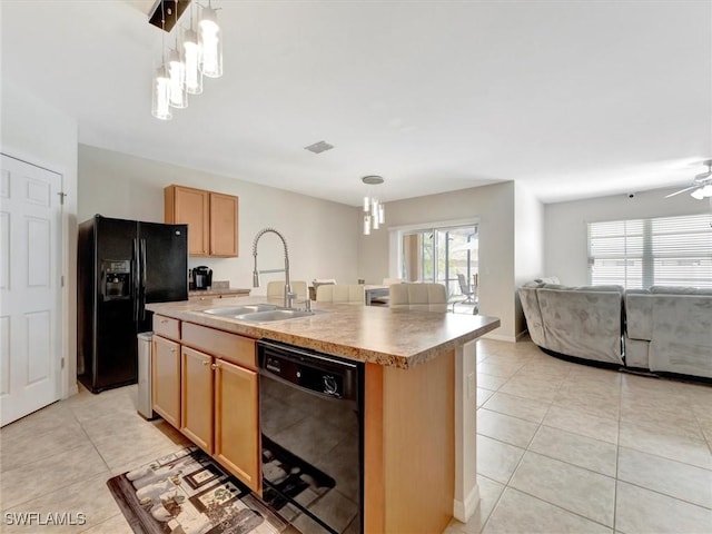 kitchen featuring sink, a center island with sink, light tile patterned floors, pendant lighting, and black appliances