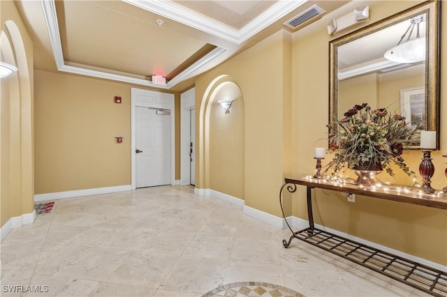 tiled foyer entrance with crown molding and a tray ceiling