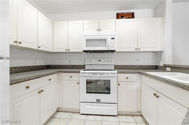 kitchen with white appliances, white cabinets, and light tile patterned flooring