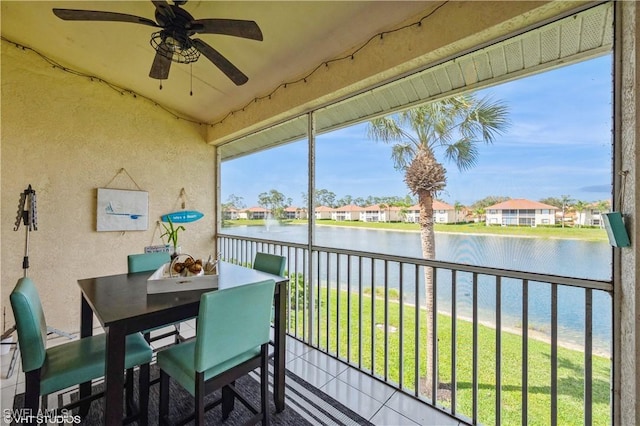 sunroom / solarium with a water view, plenty of natural light, and ceiling fan