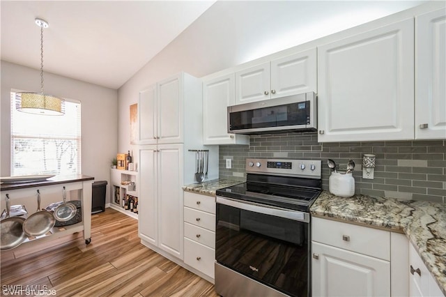 kitchen with light hardwood / wood-style flooring, lofted ceiling, white cabinetry, pendant lighting, and stainless steel appliances