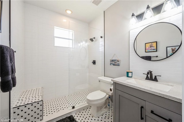 bathroom featuring toilet, tiled shower, vanity, and decorative backsplash