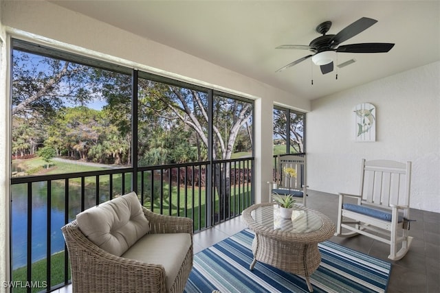 sunroom / solarium featuring a water view and ceiling fan