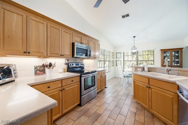 5644 Sandlewood Ct Unit 1903, Naples, FL 34110 - kitchen with stainless steel appliances, a sink, vaulted ceiling, light countertops, and hanging light fixtures