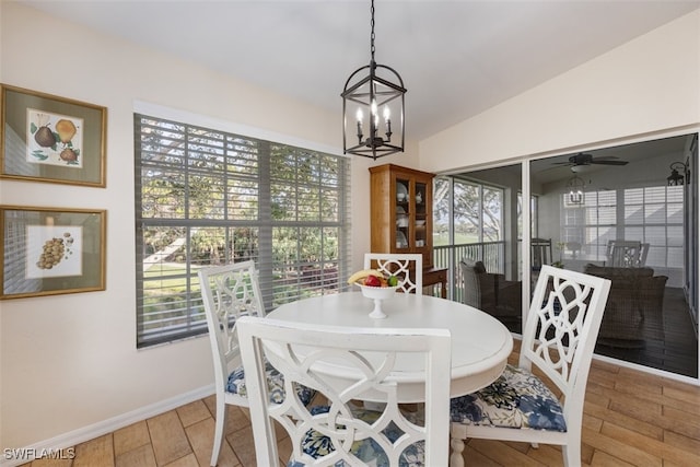 dining space featuring lofted ceiling, ceiling fan with notable chandelier, and light wood-type flooring
