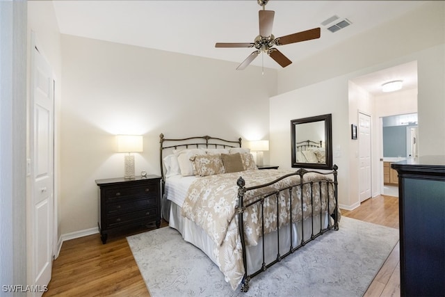 bedroom featuring ensuite bathroom, ceiling fan, and light hardwood / wood-style flooring