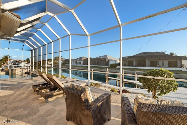 view of patio / terrace with a water view, a dock, and a lanai