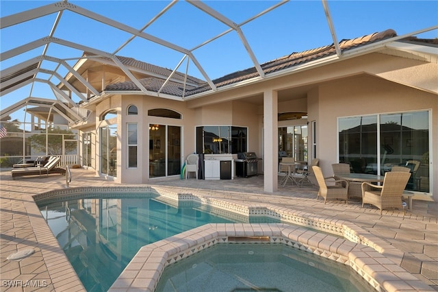 view of pool featuring an in ground hot tub, ceiling fan, a lanai, and a patio