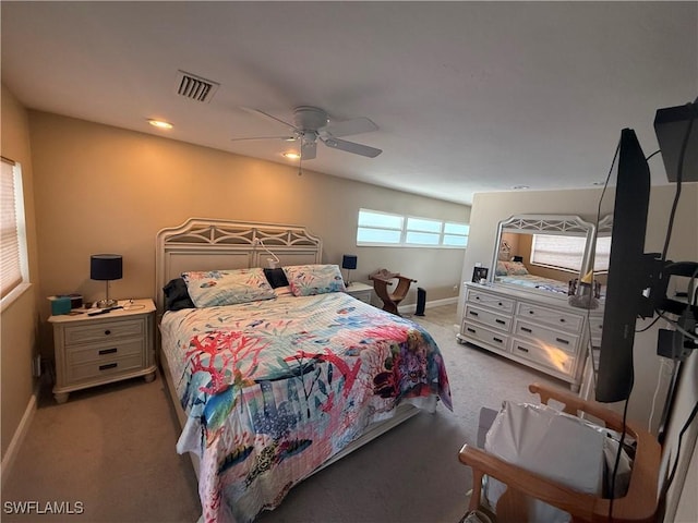 bedroom featuring a ceiling fan, visible vents, light carpet, and baseboards